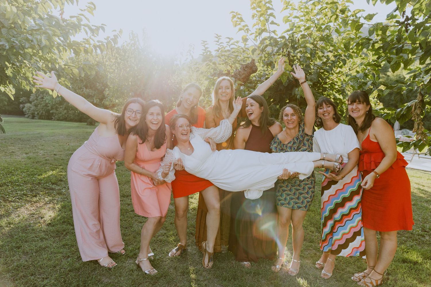 Amies qui tiennent leur amie mariée dans leur bras, pendant la golden hour. Photographe Mariage à Montpellier.