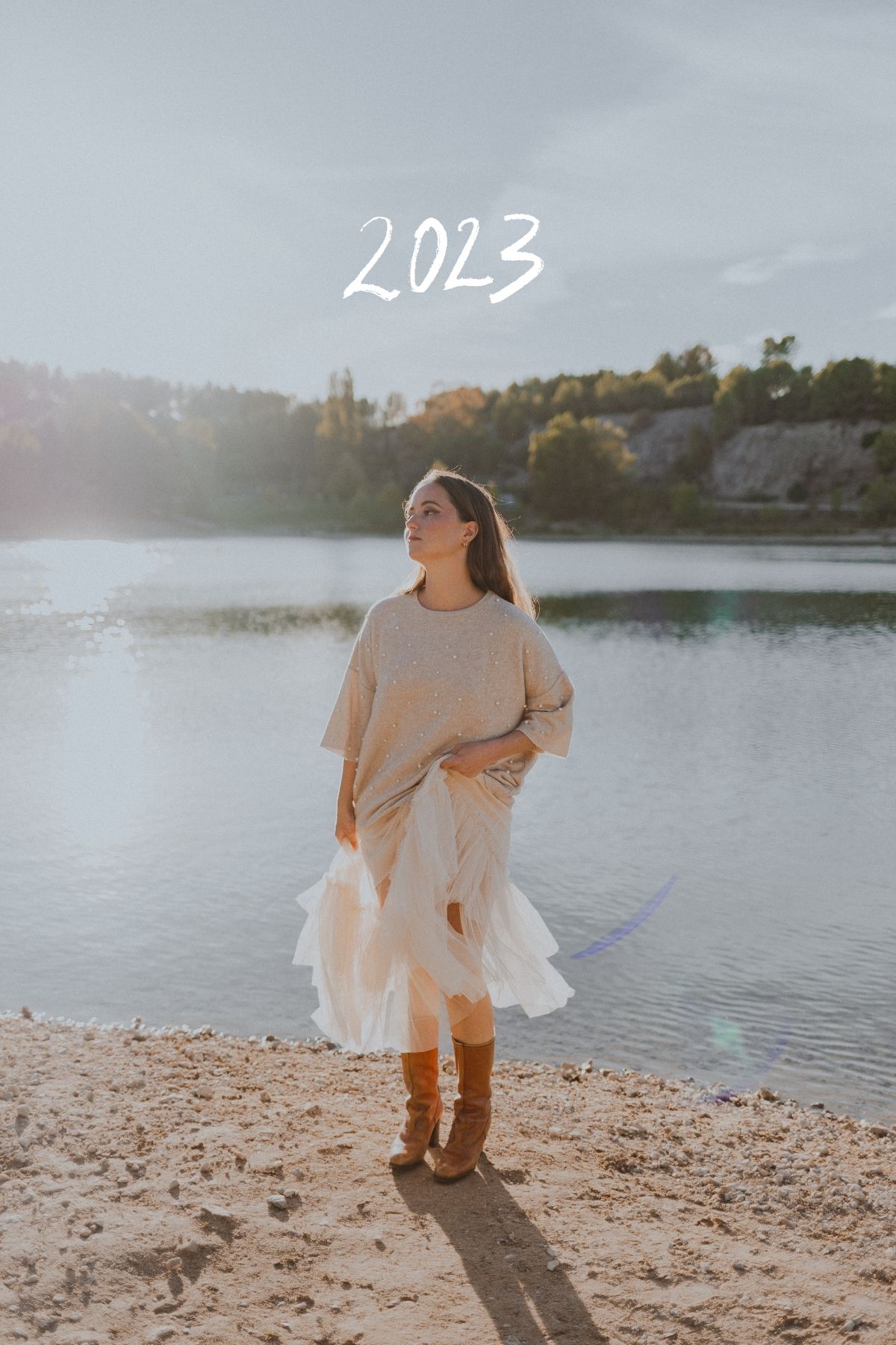 Femme joue avec sa jupe devant le Lac du Crès, près de Montpellier, baignée d'une lumière de fin de journée.