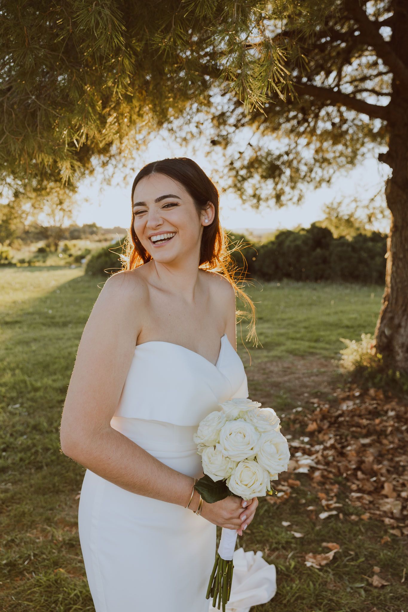 La mariée et son bouquet dans un parc pendant la golden hour. Photo par Alice Enrico, photographe Mariage à Montpellier.