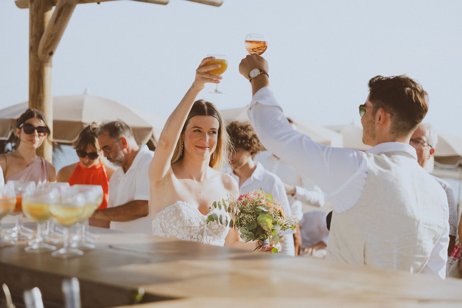 Un couple de mariés trinquent ensemble pendant le vin d'honneur. Photo par Alice Enrico, photographe mariage à Montpellier.