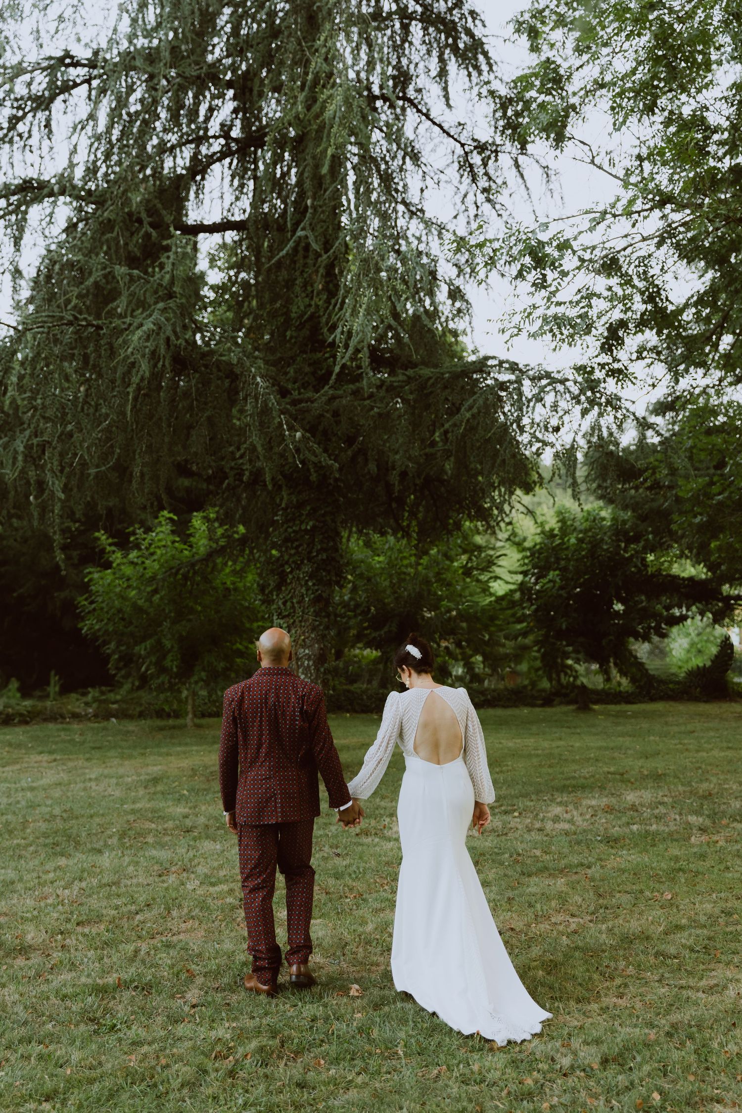 Un couple marche main dans la main dans un décor naturel. Photo par Alice Enrico, photographe Mariage à Montpellier.