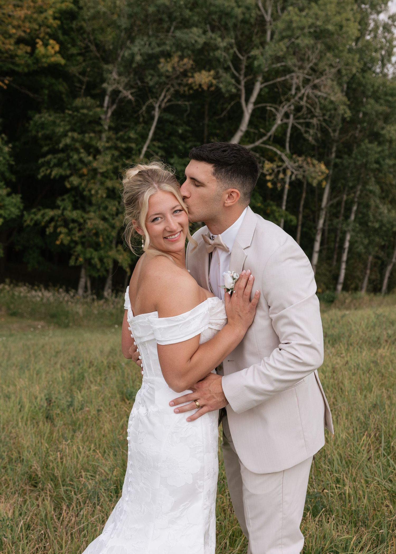 Romantic sequence of couple in white sharing intimate moments in field.