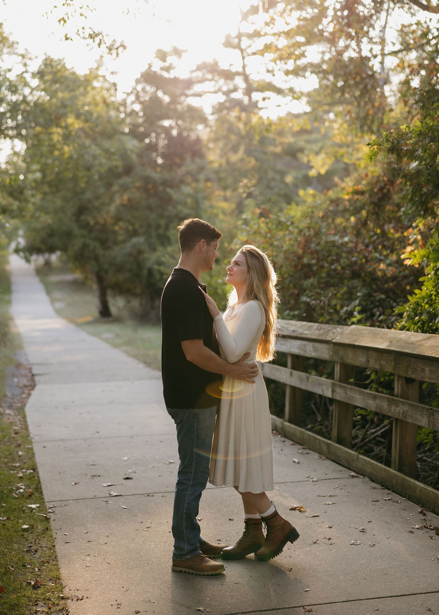 Couple sharing sweet moments on a wooden boardwalk surrounded by autumn foliage.