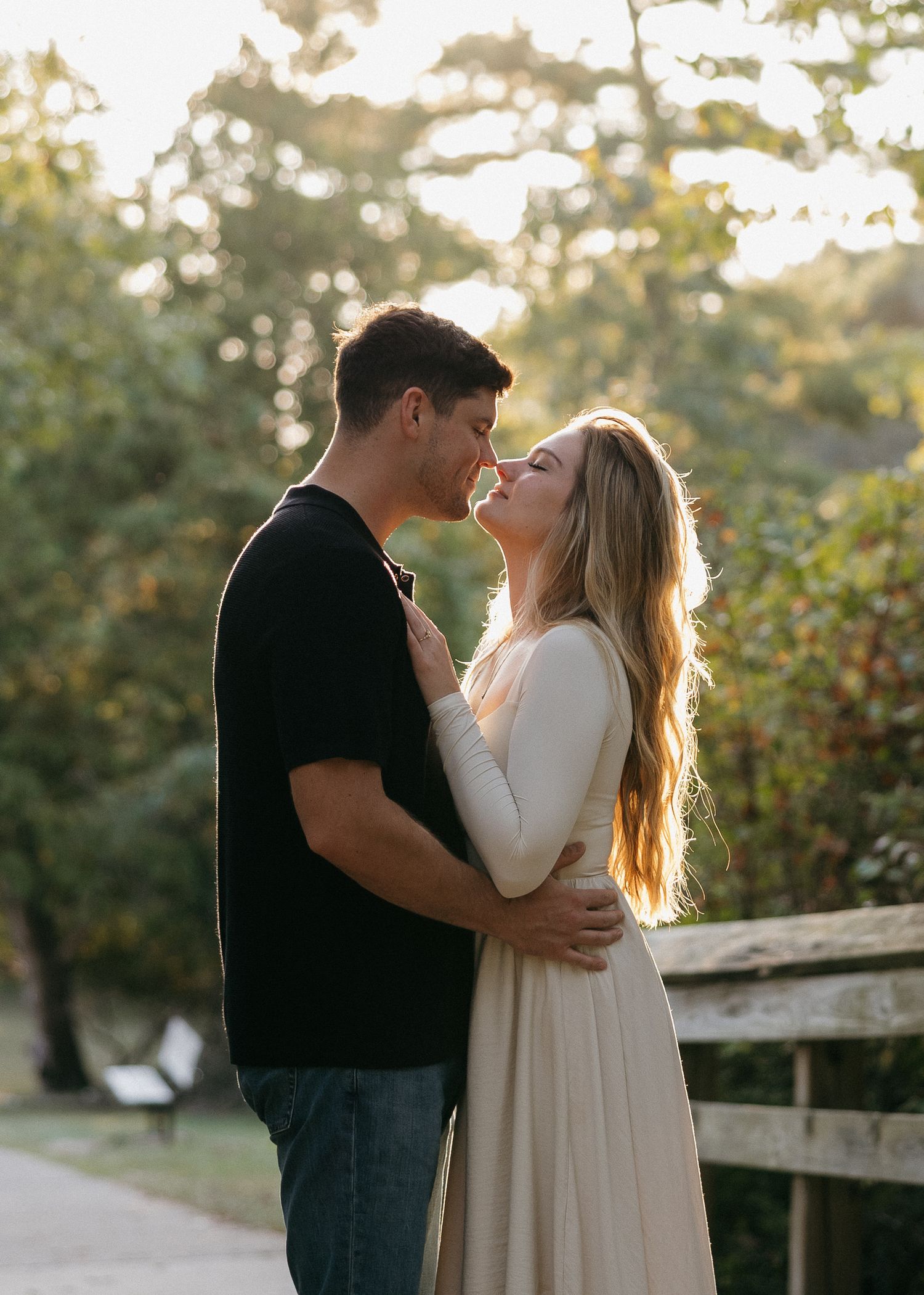 Romantic couple embracing during sunset in a garden setting.