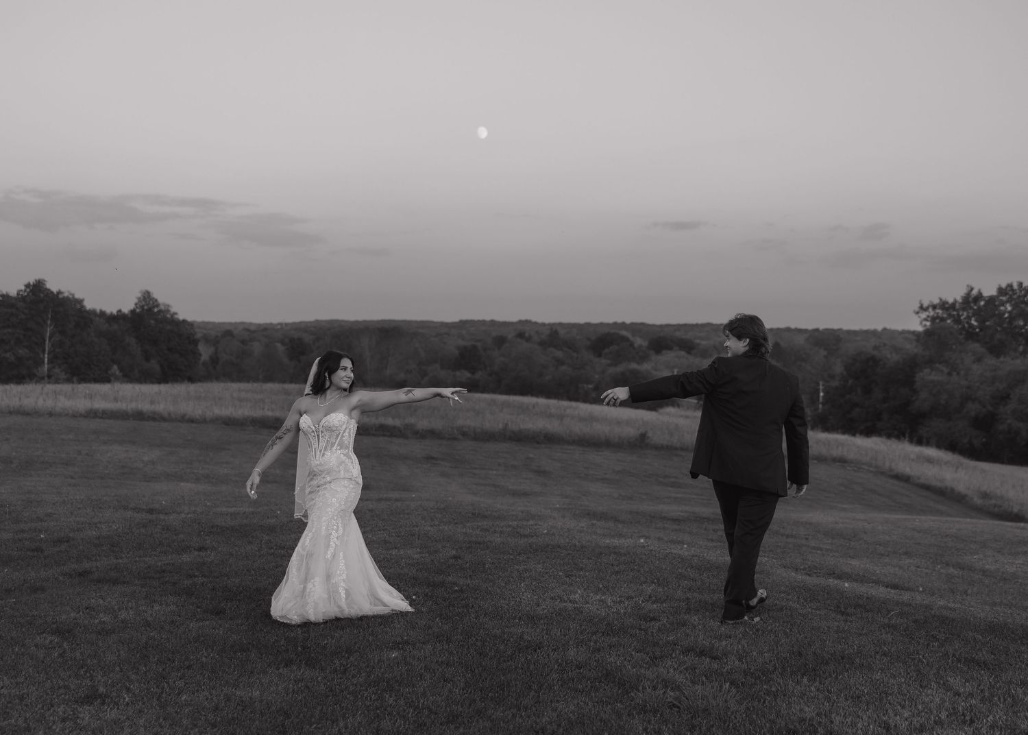 Black and white landscape photos of wedding couple in open field.