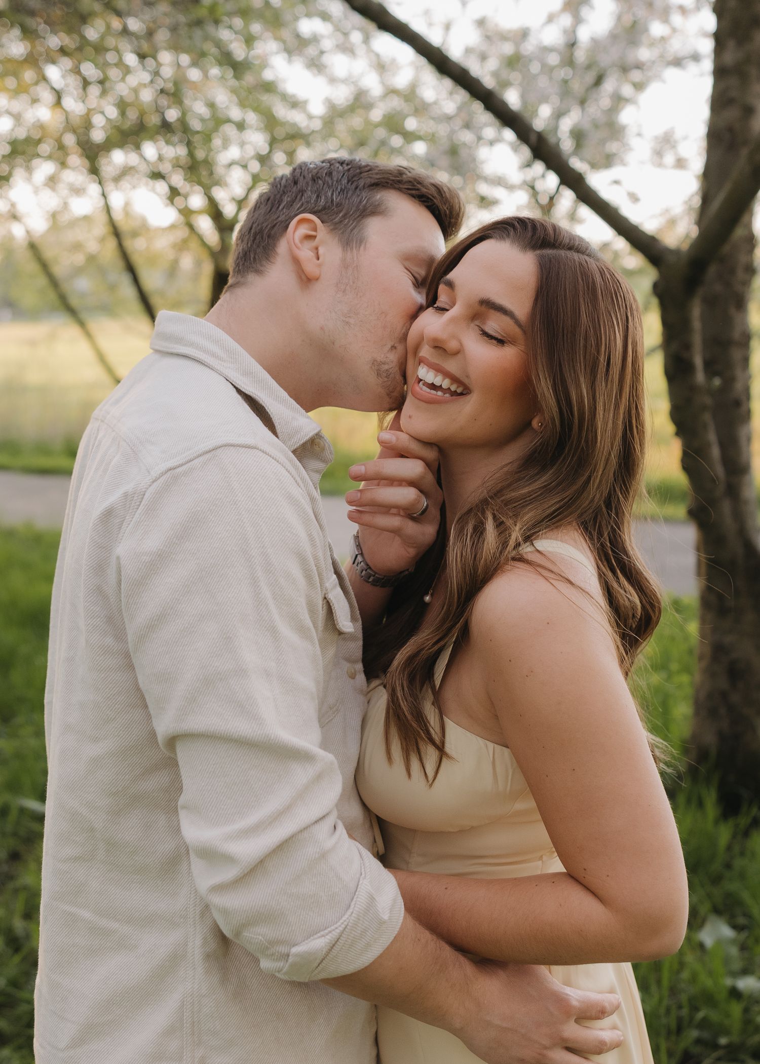 A romantic outdoor portrait of a couple sharing a tender moment in a natural setting.