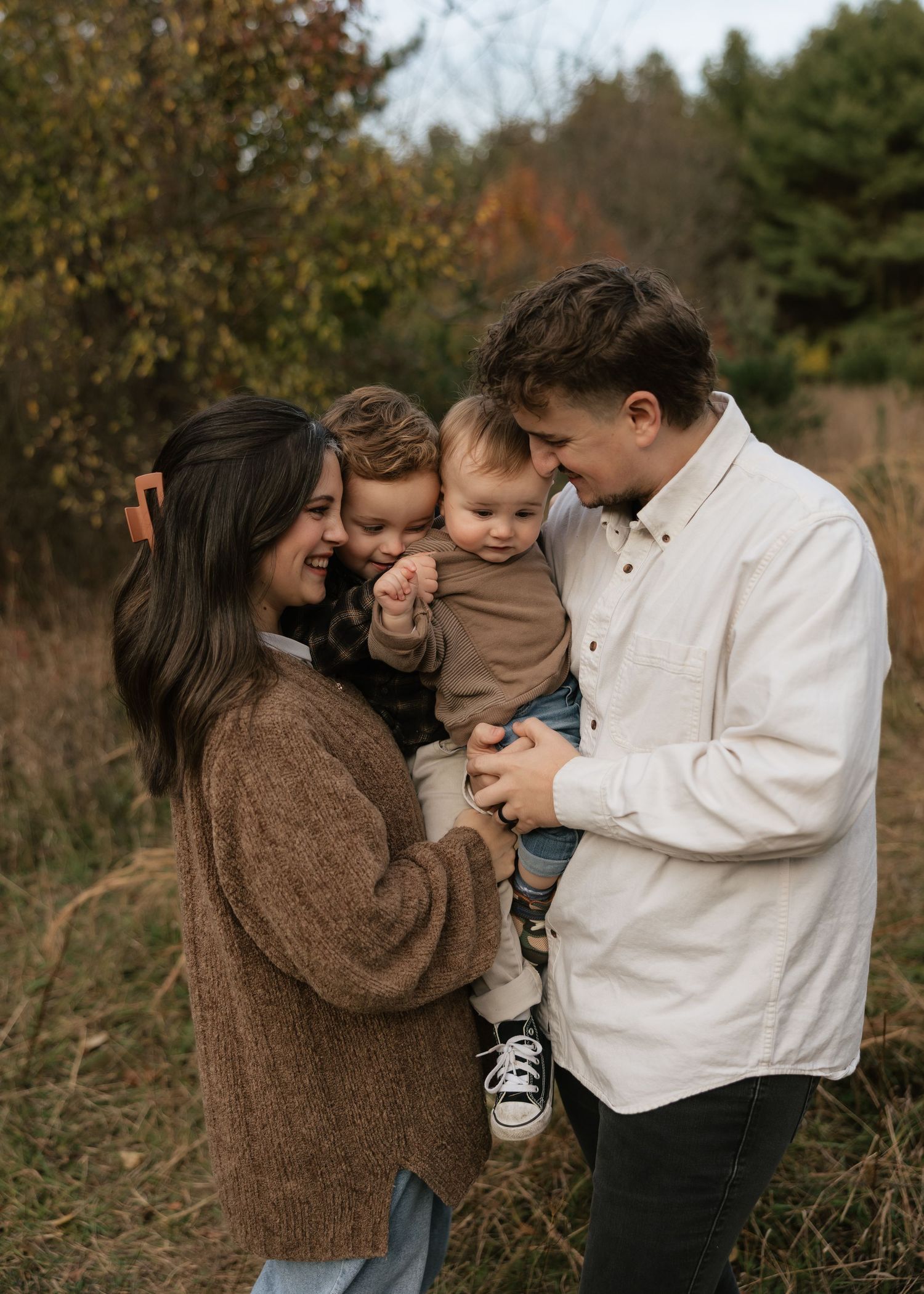 Family shares intimate moment together in autumn outdoor setting.