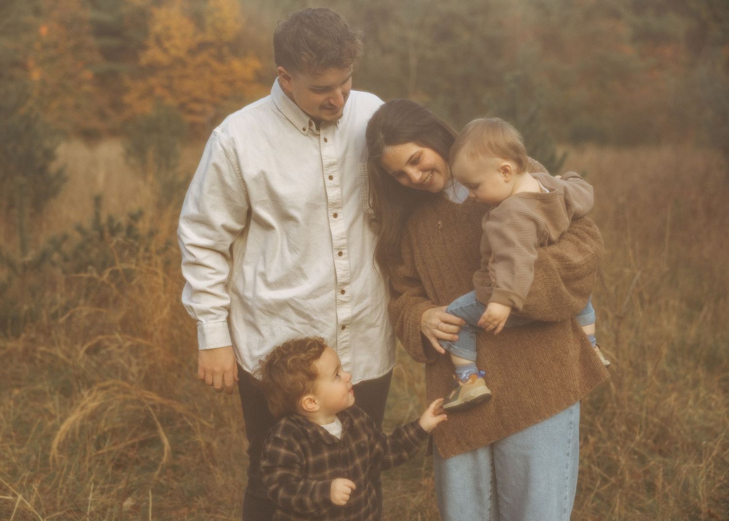 Family lifestyle session captured in warm autumn tones outdoors.