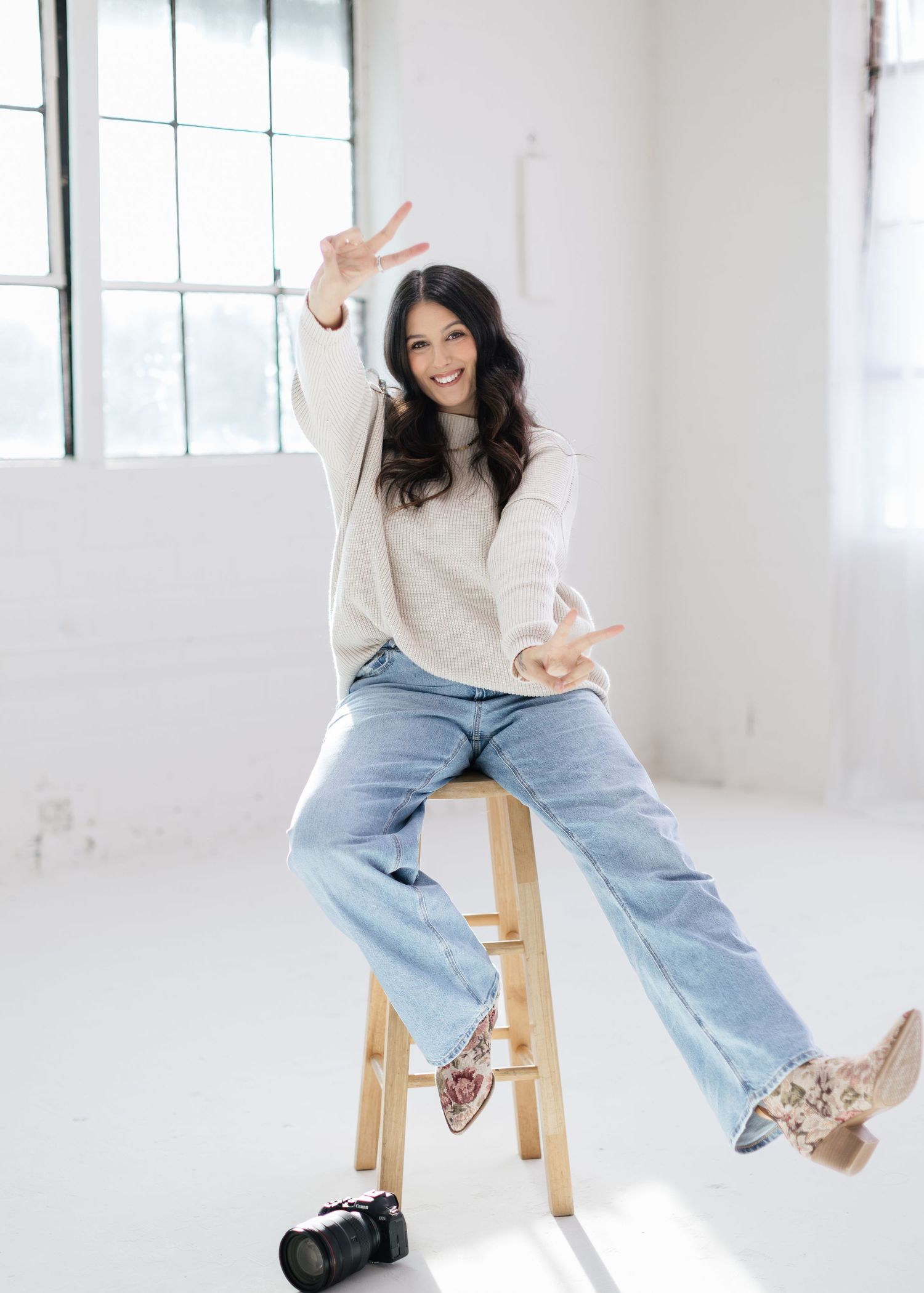 Playful portrait session in bright studio with camera equipment.