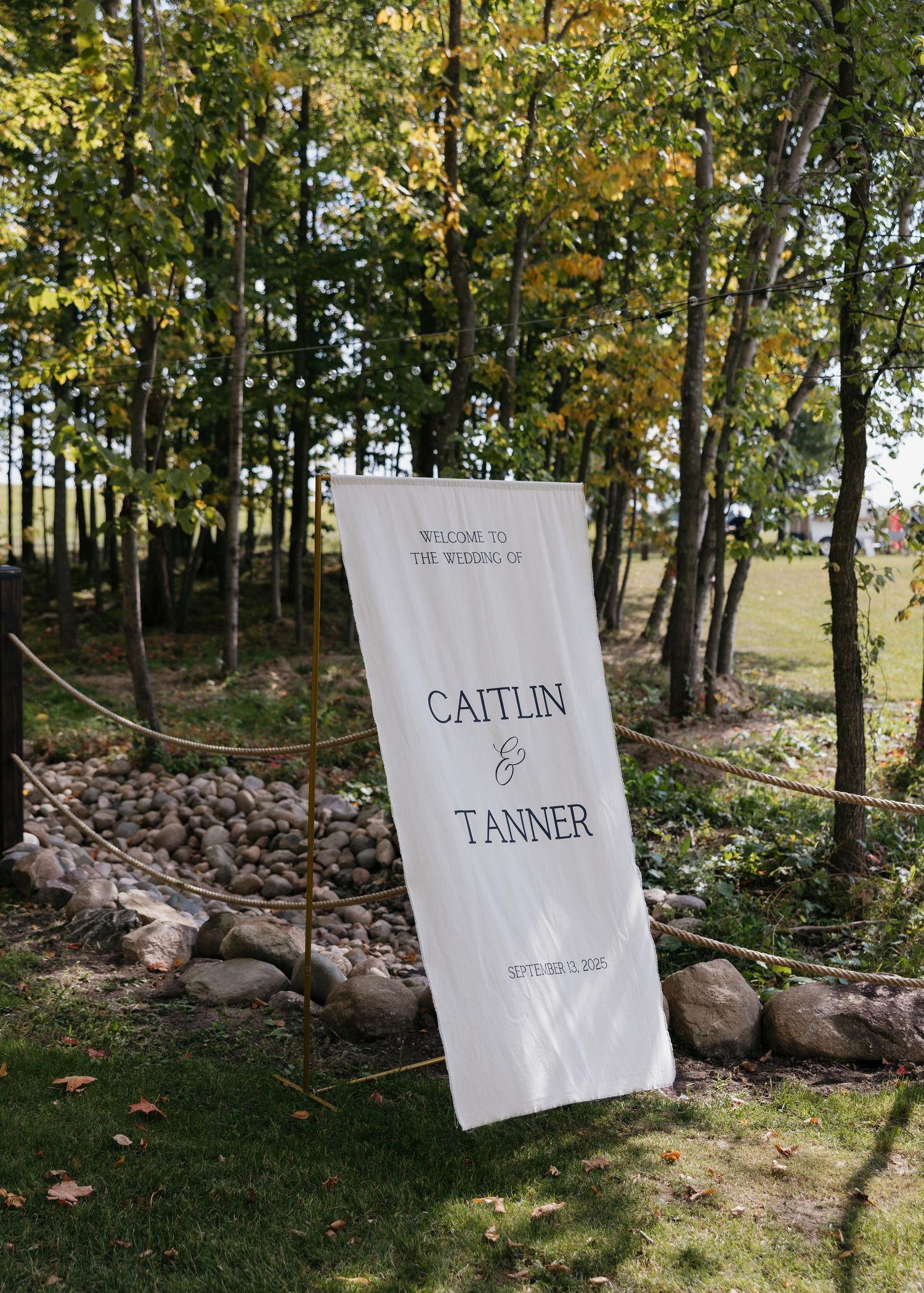 Wedding welcome signs displayed in wooded outdoor setting.
