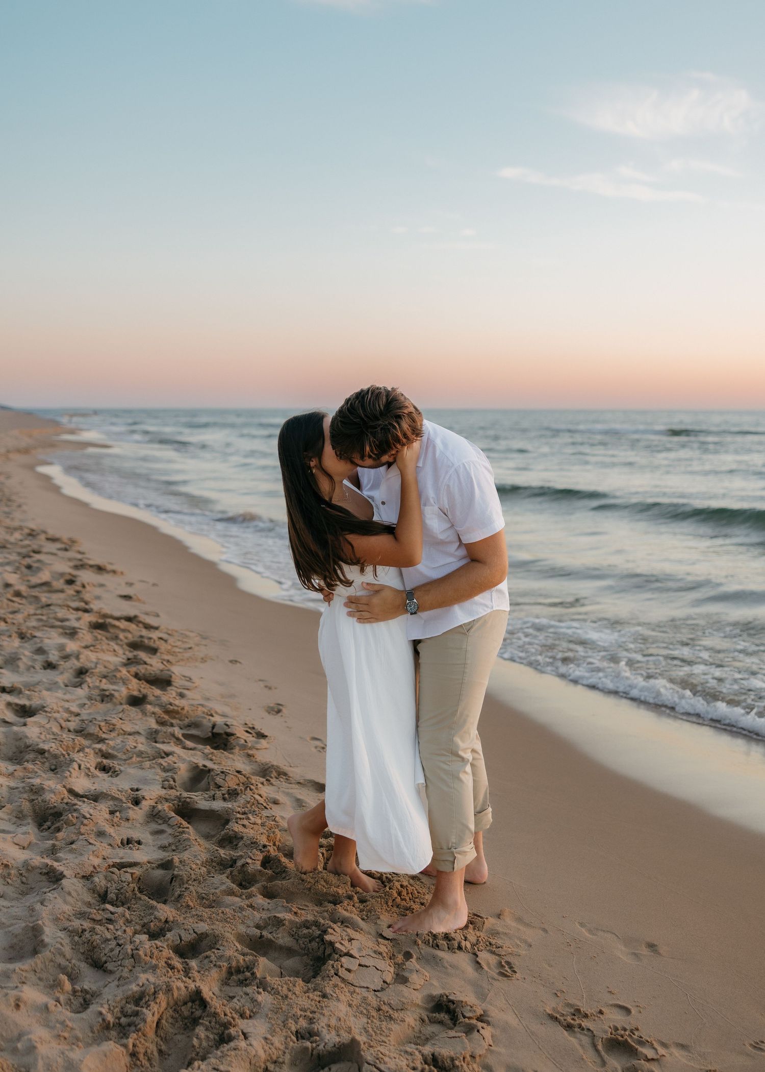 A couple sharing an intimate moment on the beach during golden hour.