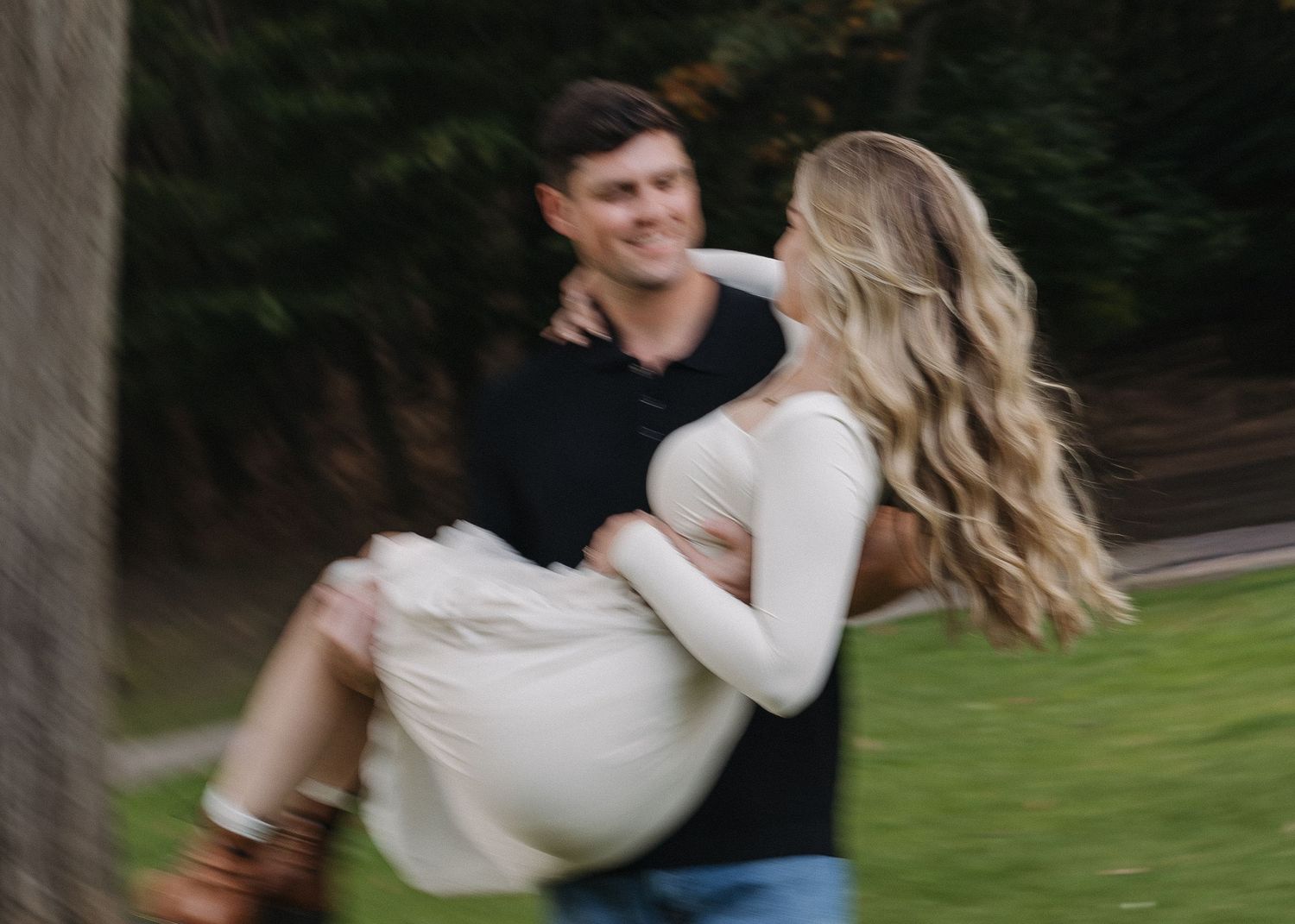 Couple dancing and spinning in an outdoor garden setting.