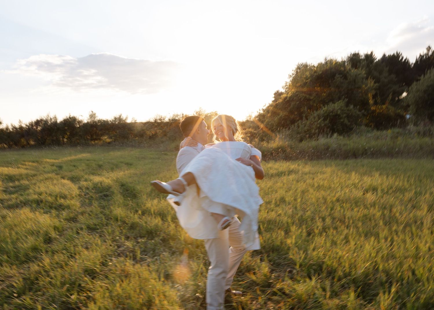 Golden hour shots of couple running through tall grass field.