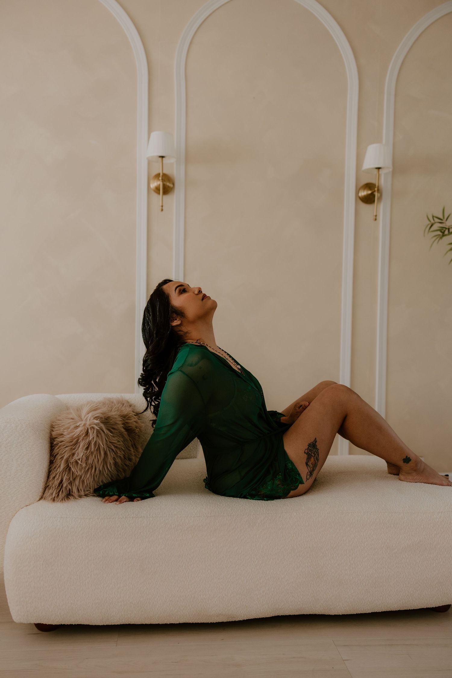 Elegant boudoir portrait in emerald robe on cream sofa by Nashville and Clarksville boudoir photographer.