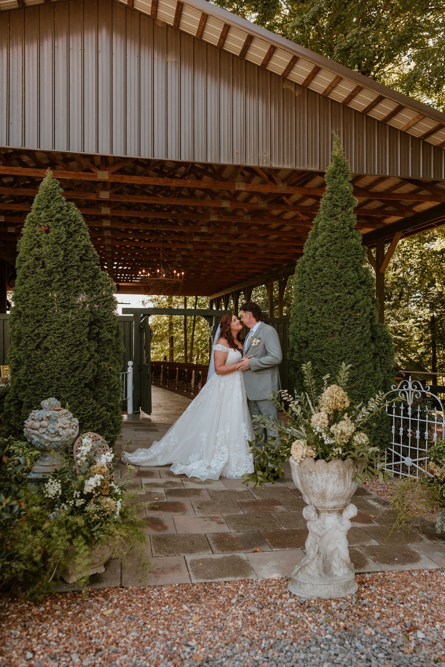 Bride and groom sharing a romantic wedding portrait beneath a covered outdoor ceremony space at a Tennessee wedding venue.
