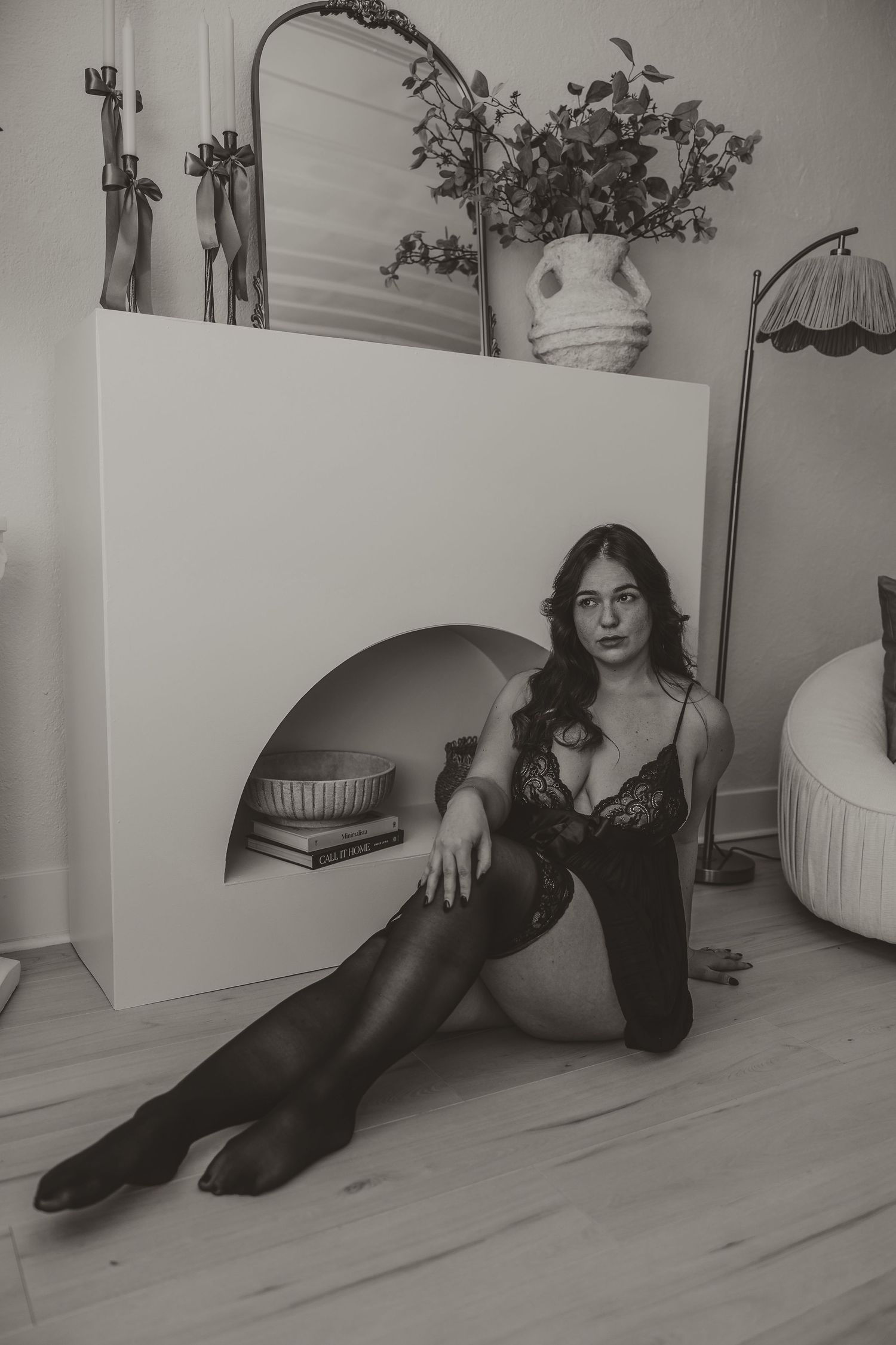 Light and airy boudoir portrait in black lace lingerie with feminine styling in a warm neutral Nashville studio. luxury boudoir experience.