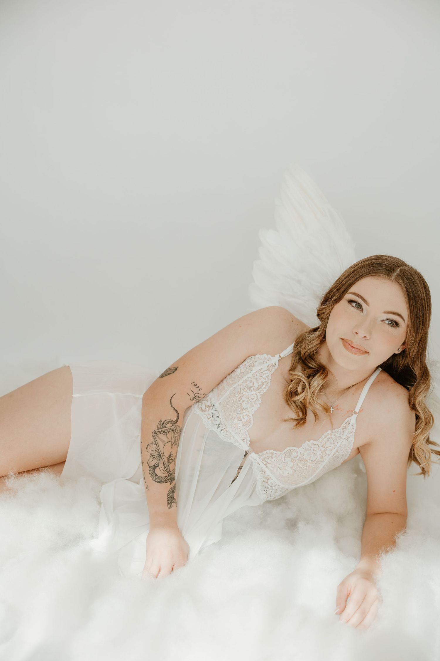 Angel-inspired boudoir portrait in white lace and wings by middle tennessee nashville boudoir photographer.
