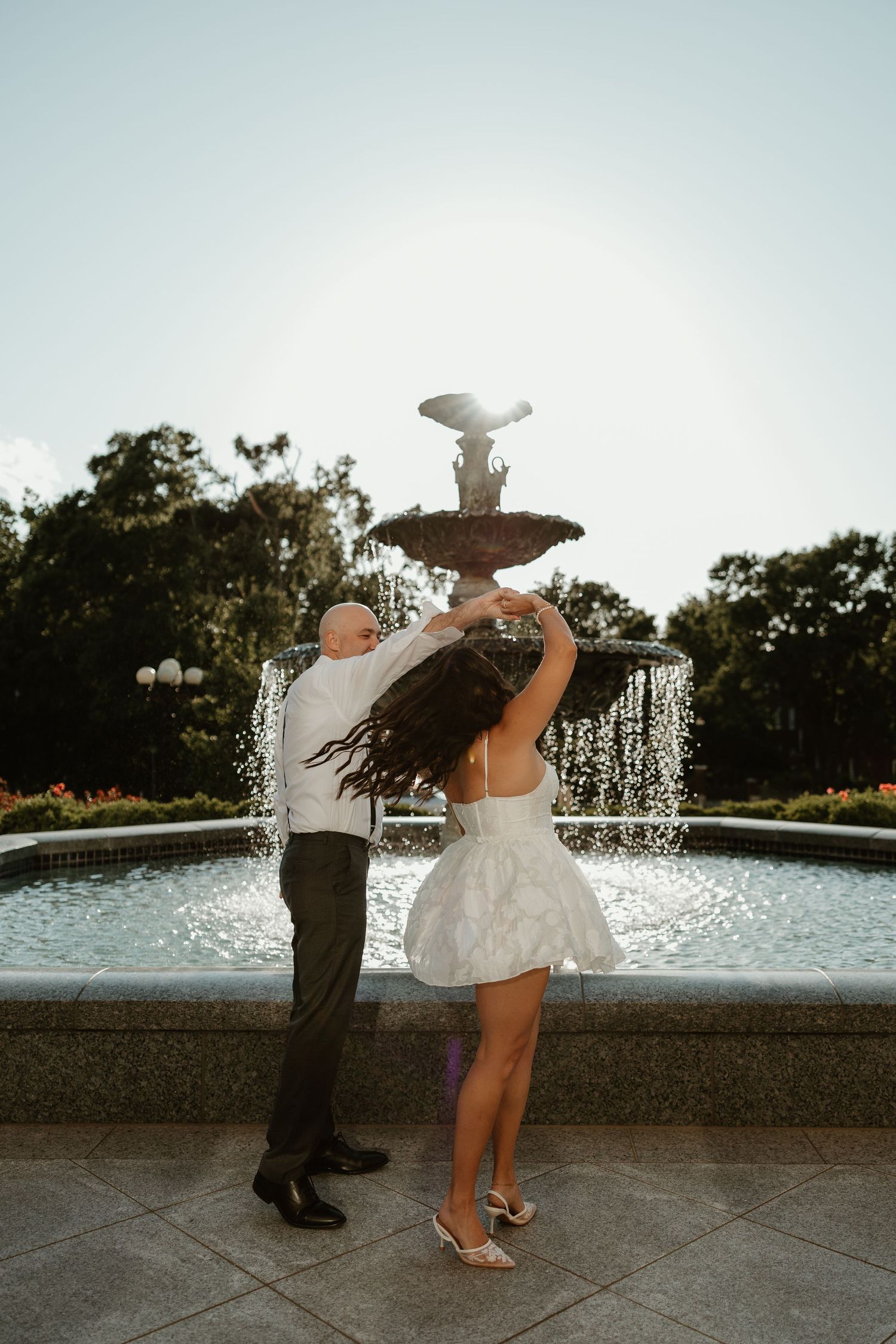Romantic engagement photo of a couple dancing beside a fountain in Nashville, Tennessee candid playful elegant photos