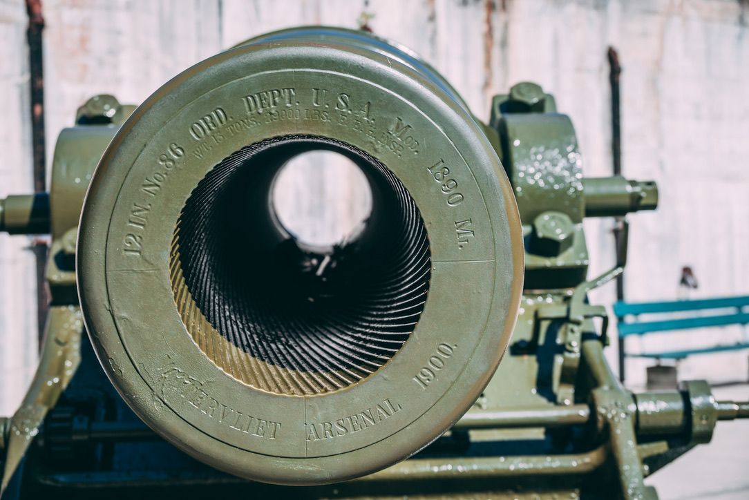 Close-up view of a vintage cannon barrel showing spiral rifling grooves and engraved markings.