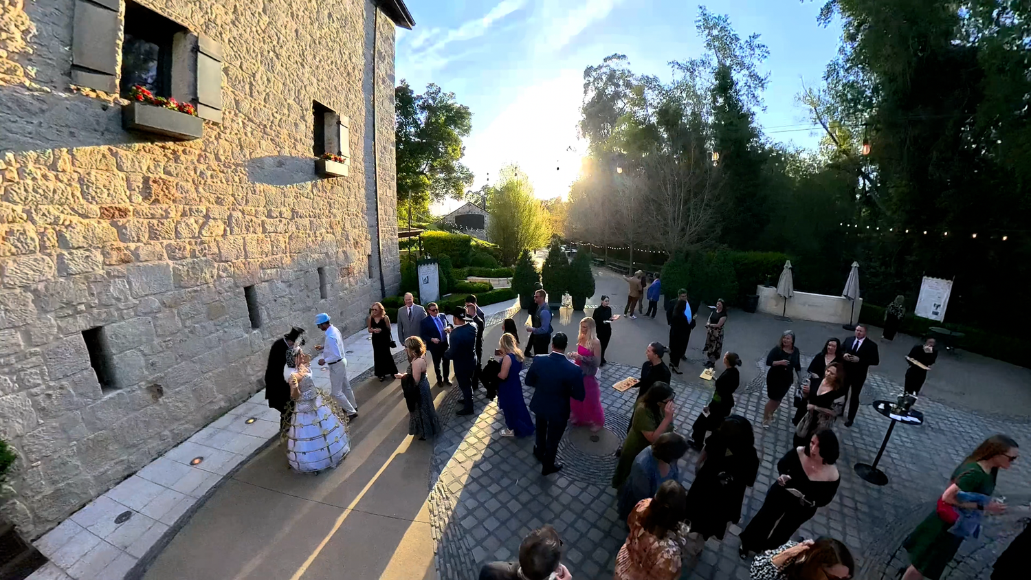 Sales incentive trip evening gala in Sonoma California. People gathered at a winery drinking wine and mingling.