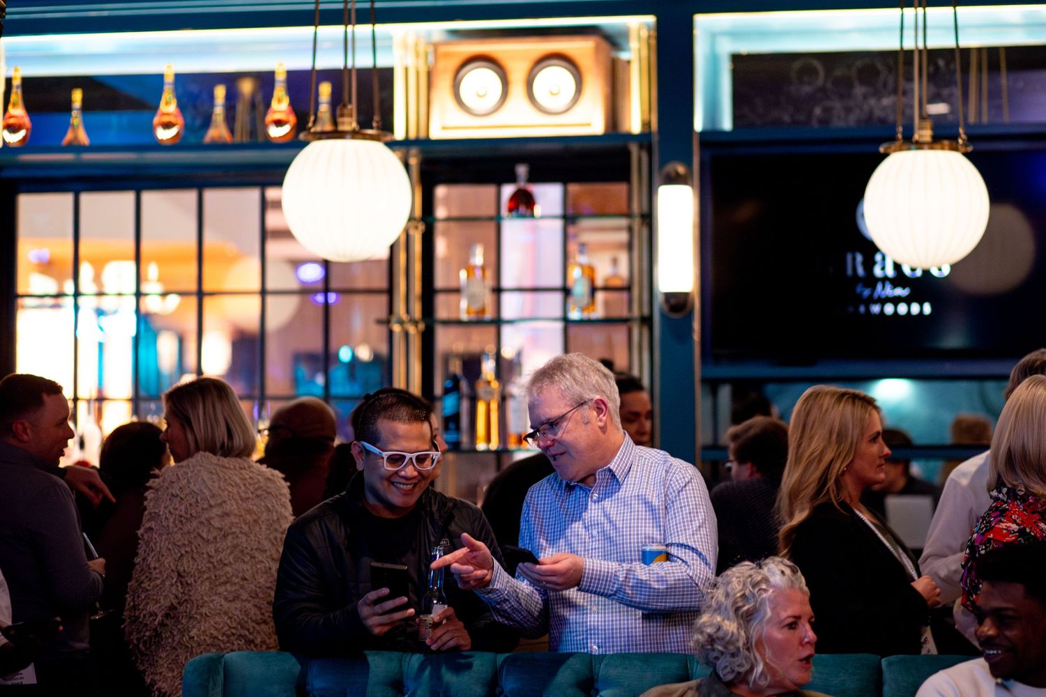 Environment and two men sharing a photo at a sales event party.