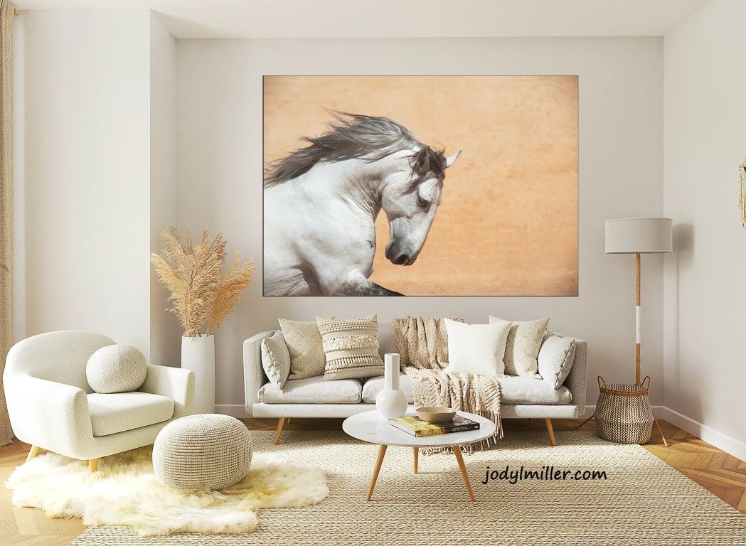 White horse portrait painting on canvas displayed above beige sofa in modern neutral living room with cream decor.