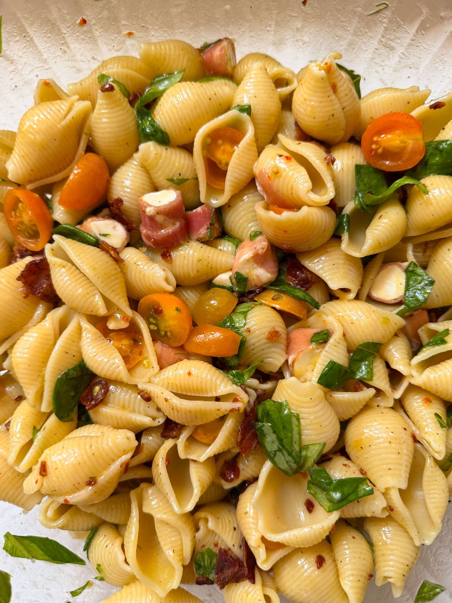 Shell pasta salad with cherry tomatoes, fresh basil, crispy bacon, and mozzarella tossed in a light herb dressing.