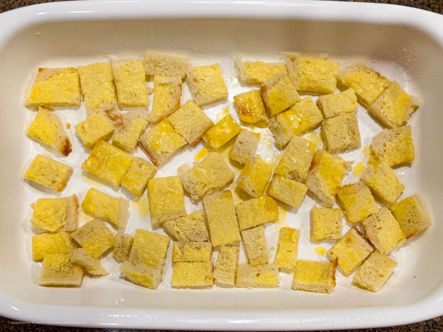 Seasoned tofu cubes arranged in a white baking dish, ready to be baked to golden perfection.