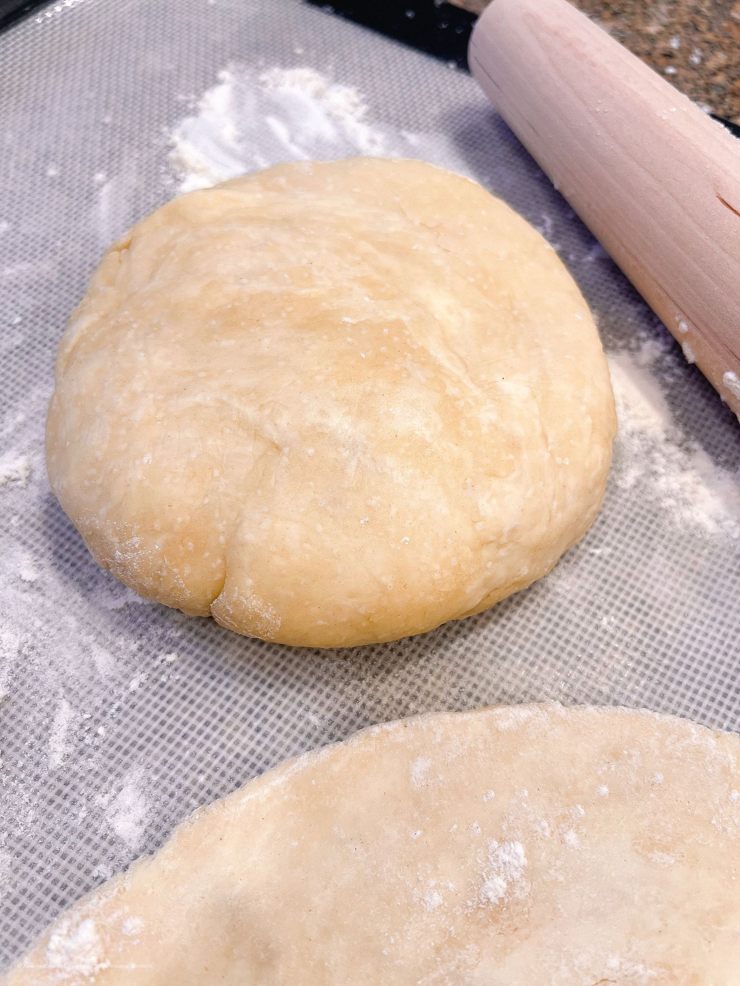 Pastry dough at various stages of being rolled out on a baking mat.