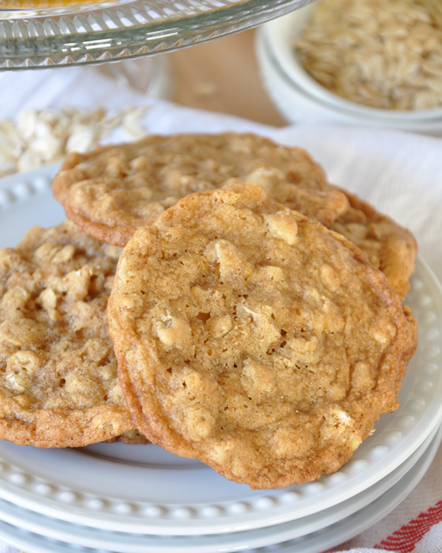 Golden brown oatmeal cookies with crispy edges served on a white plate.