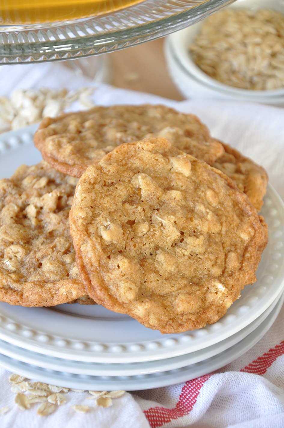 Freshly baked oatmeal cookies with nuts displayed on white plates.