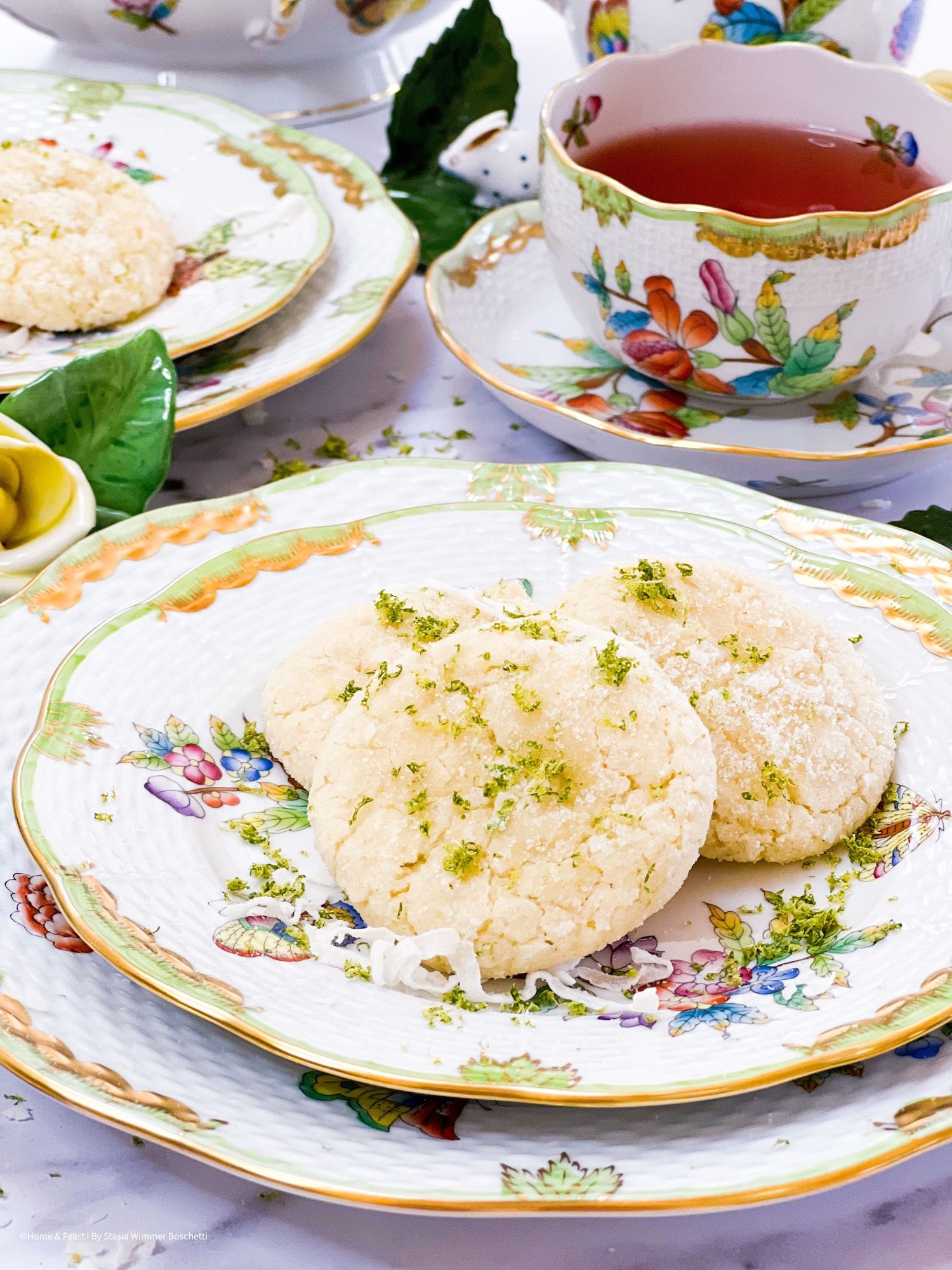 Elegant tea service with decorative floral plates and light pastries.