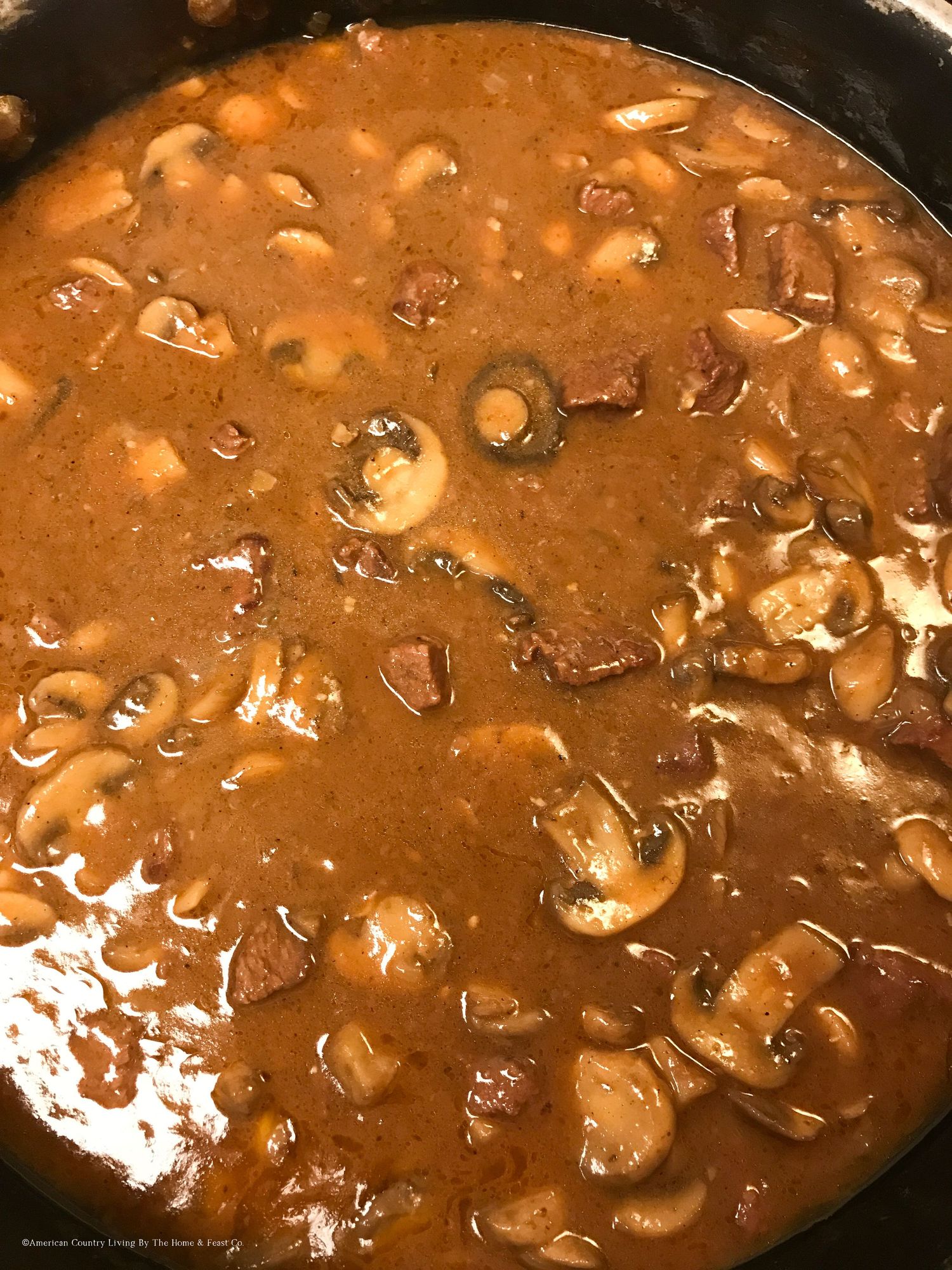 Hearty beef and mushroom stroganoff sauce simmering in a cast iron skillet.