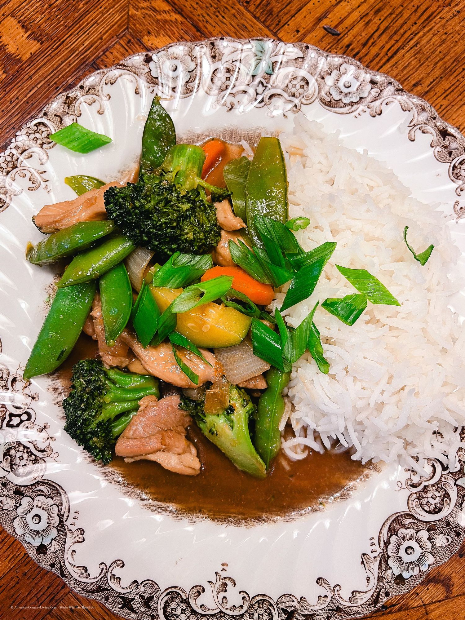 Asian-inspired chicken and vegetable dish served with white rice on a decorative platter.