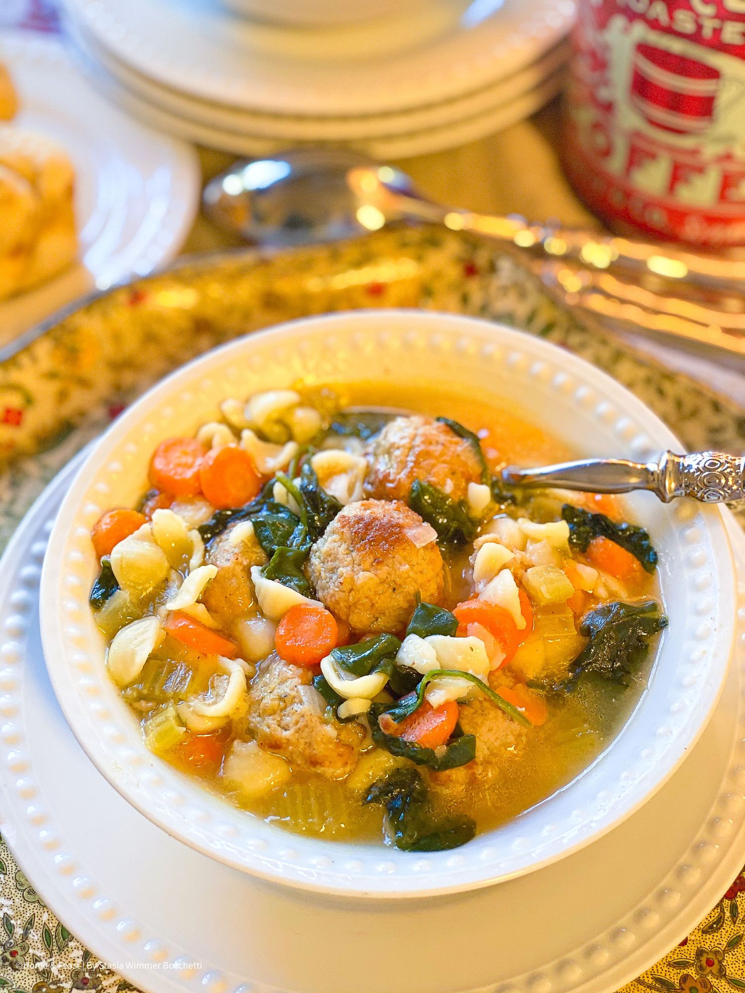Hearty Italian wedding soup with meatballs, vegetables, and pasta served in a white bowl.