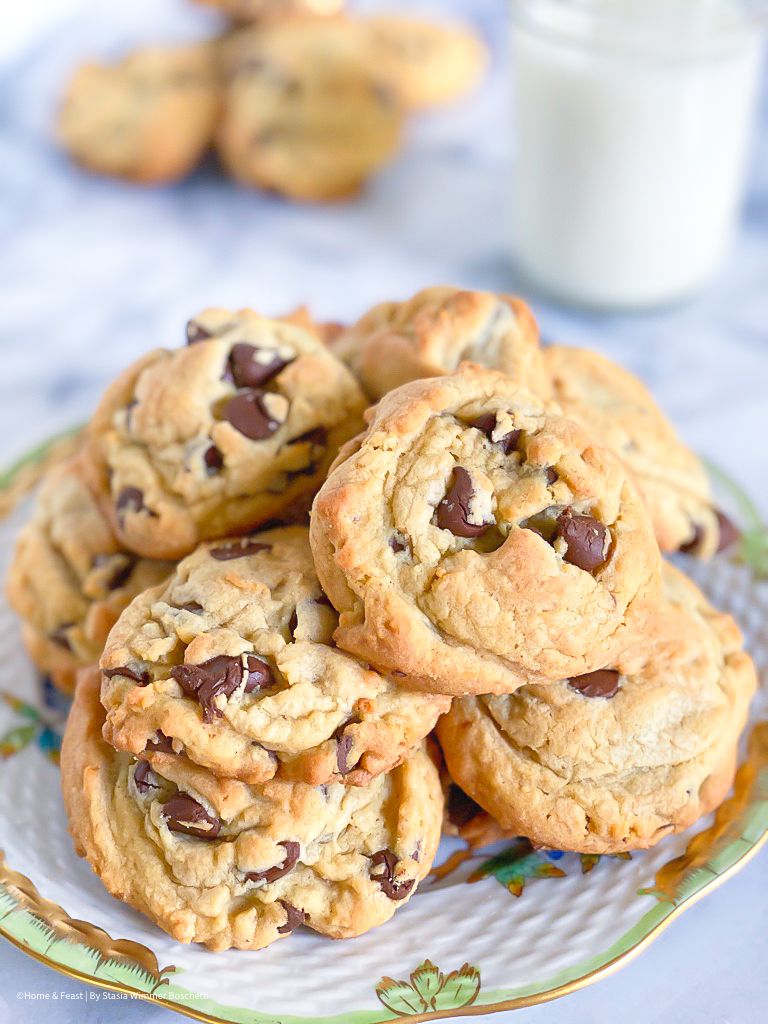 Fresh baked chocolate chunk cookies displayed on a floral patterned plate.