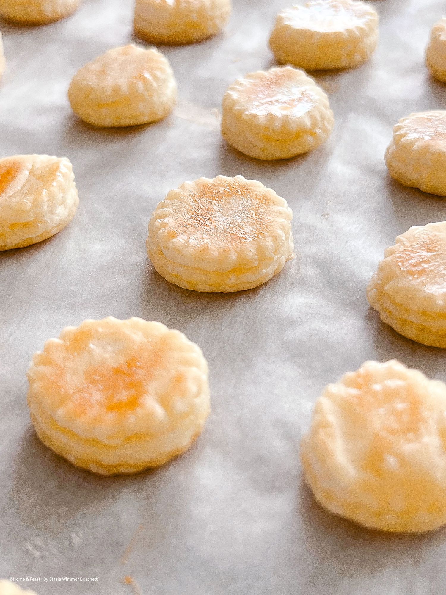 Glazed cream puffs arranged on parchment paper with golden caramelized tops.
