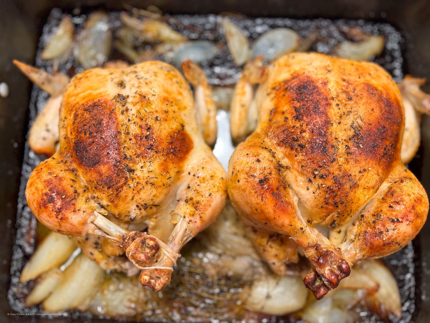 Golden brown roasted chicken thighs with crispy skin in a baking dish.