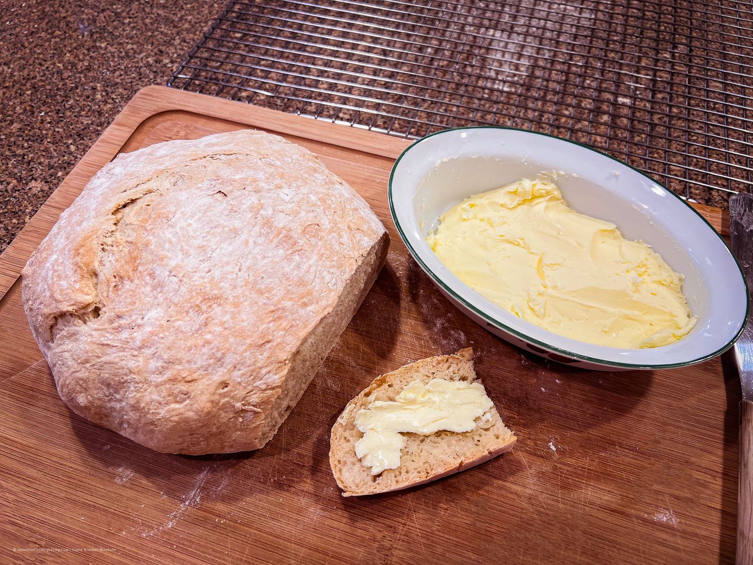 Freshly baked bread rolls served with butter on a wooden cutting board.