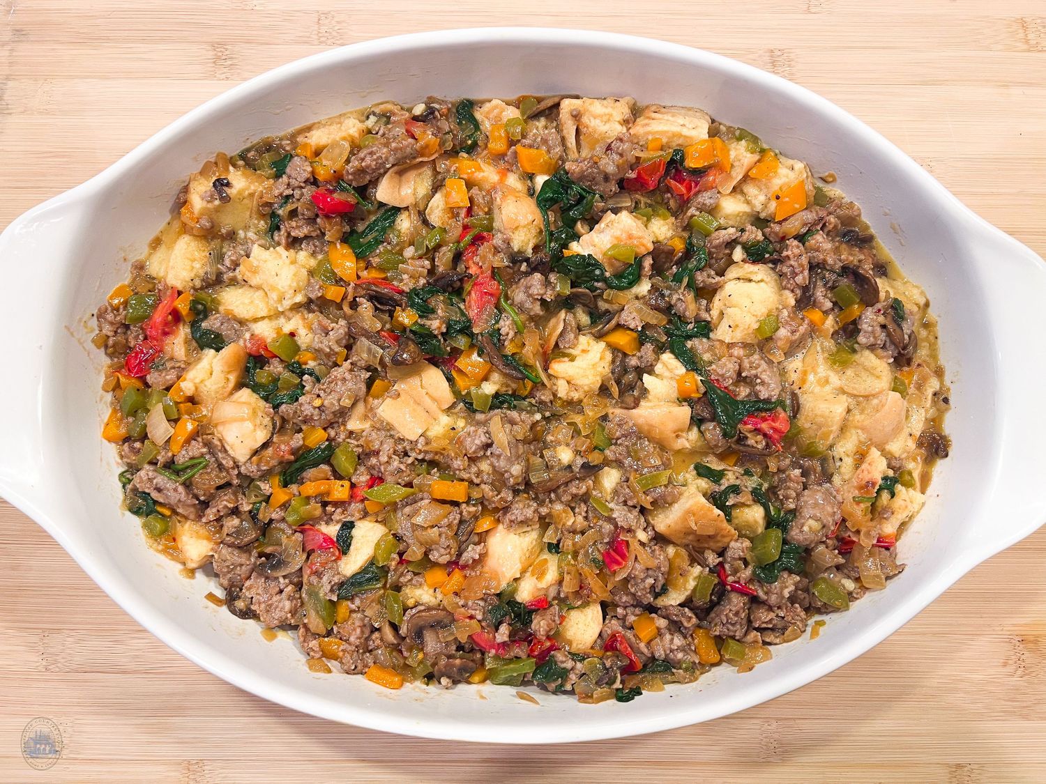 Savory rice and vegetable casserole with colorful peppers in white baking dish.