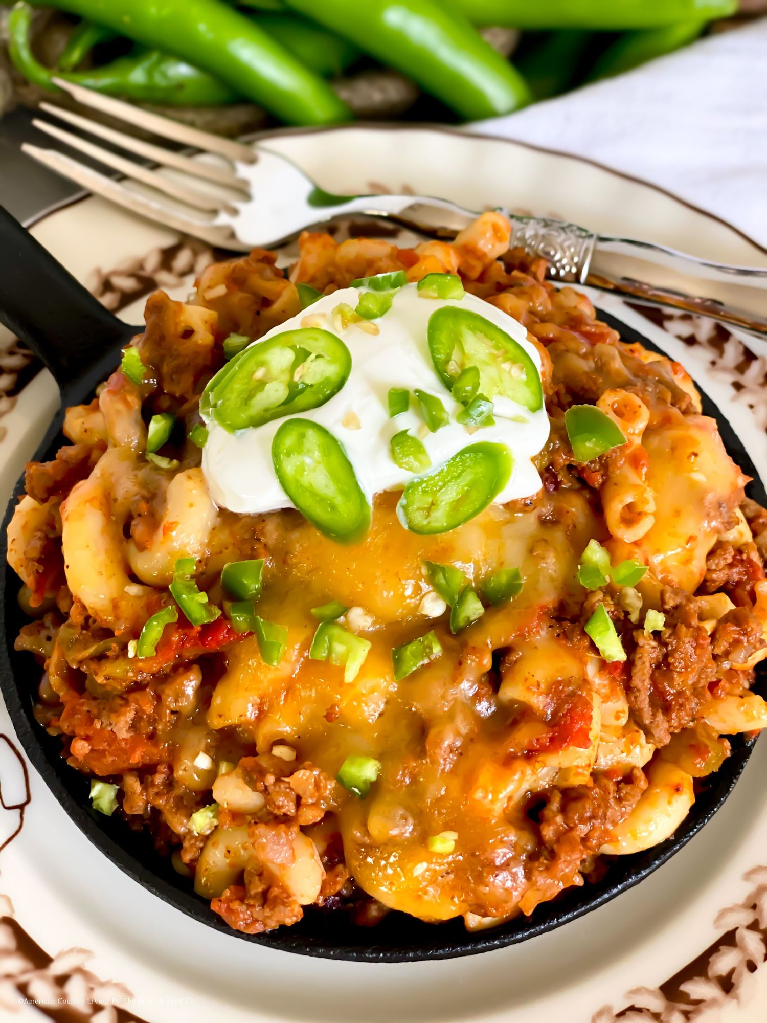 Creamy taco pasta skillet topped with fresh jalapenos, sour cream and melted cheese.