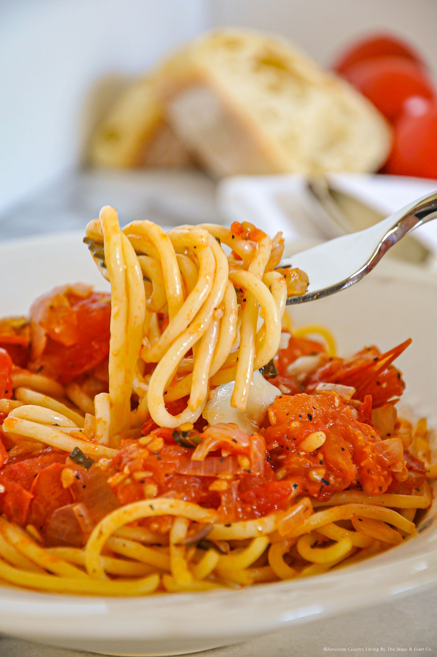 Linguine pasta with spicy tomato sauce twirled on a fork.