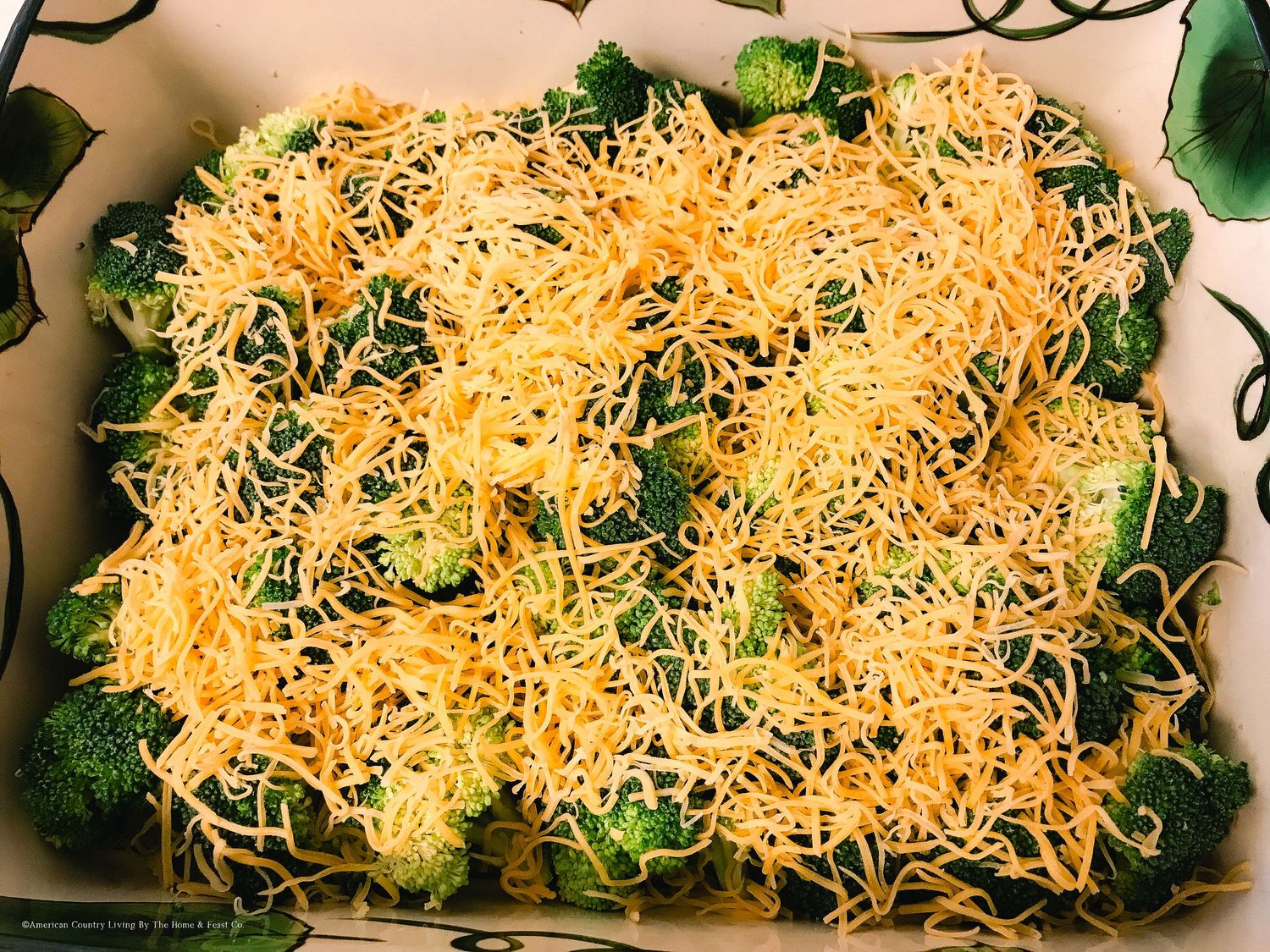 Casserole topped with melted shredded cheddar cheese and fresh herbs.