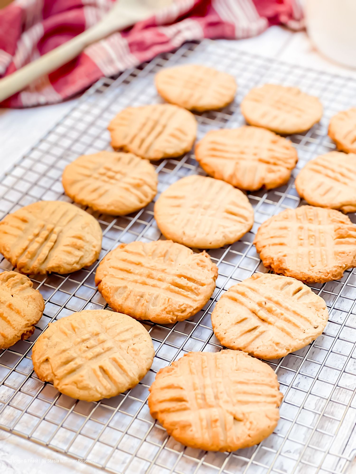 Perfectly arranged homemade cookies with fork-pressed pattern on a metal cooling rack.