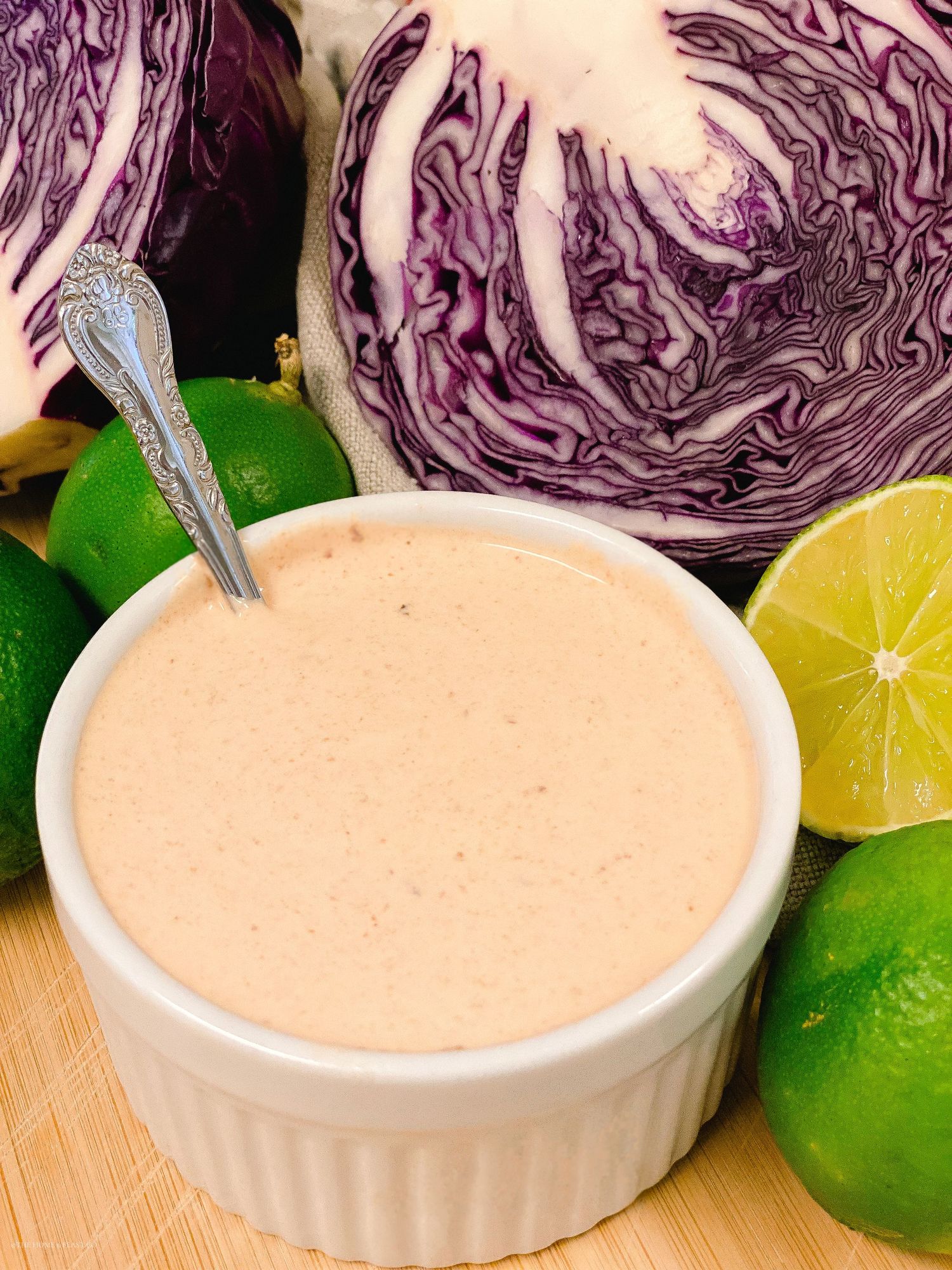 Pink dressing served in a ruffled white bowl with fresh citrus and cabbage.