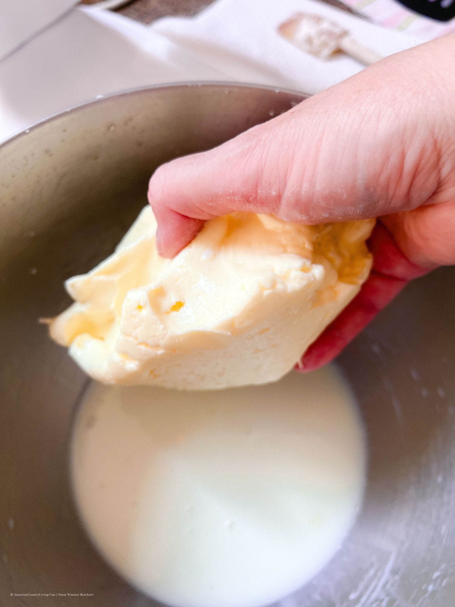 Butter being added to a mixing bowl for baking preparation.