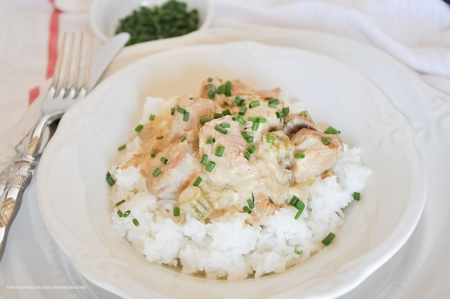 Creamy chicken and mushroom sauce served over a bed of white rice garnished with fresh chopped chives.