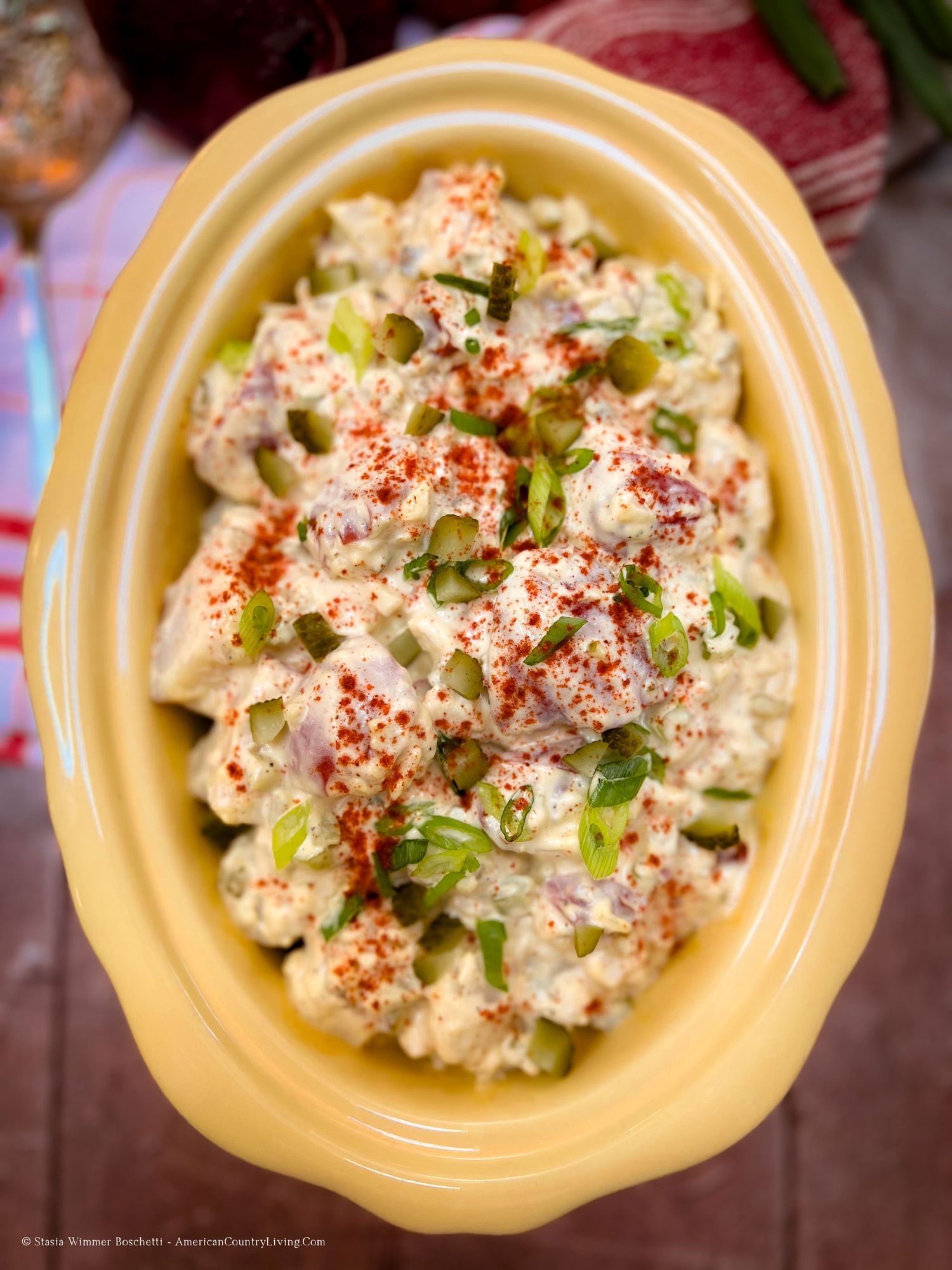 Homemade chicken salad with fresh herbs and spices in a yellow serving dish.