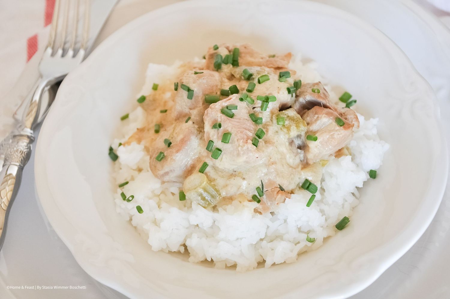 White rice topped with creamy meat sauce and garnished with fresh herbs.