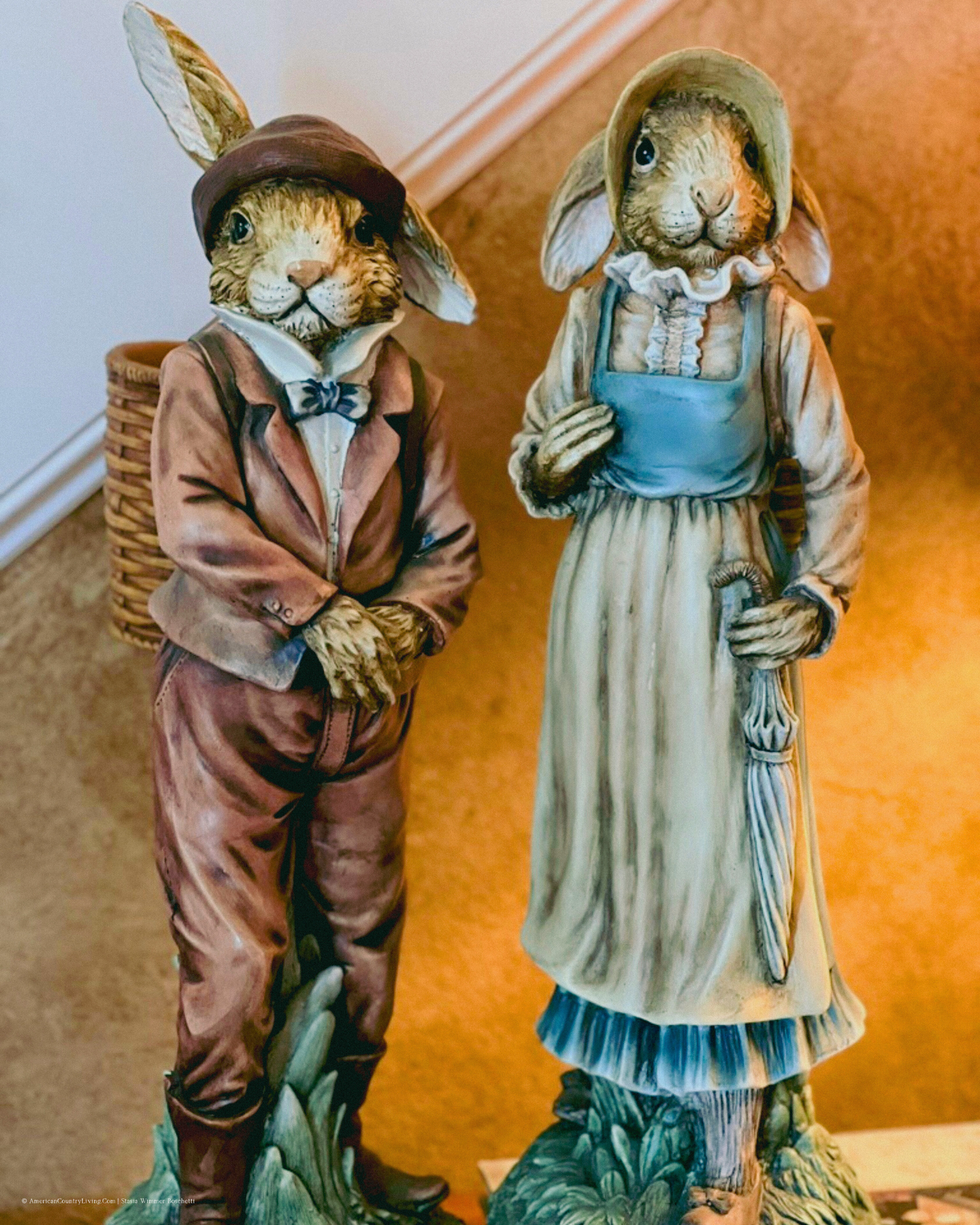 Decorative figurines of dressed rabbits in Victorian-style clothing standing together.